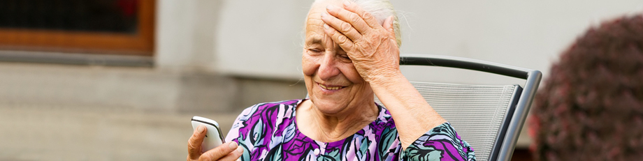 Ältere Frau mit Handy - Logopädie am Riedberg